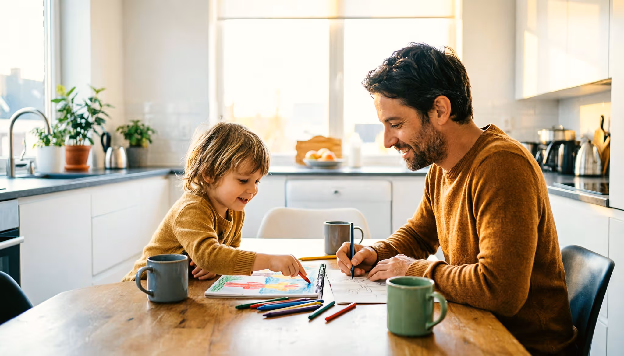 A parent and young child drawing together at the kitchen table in a bright Dutch home 
