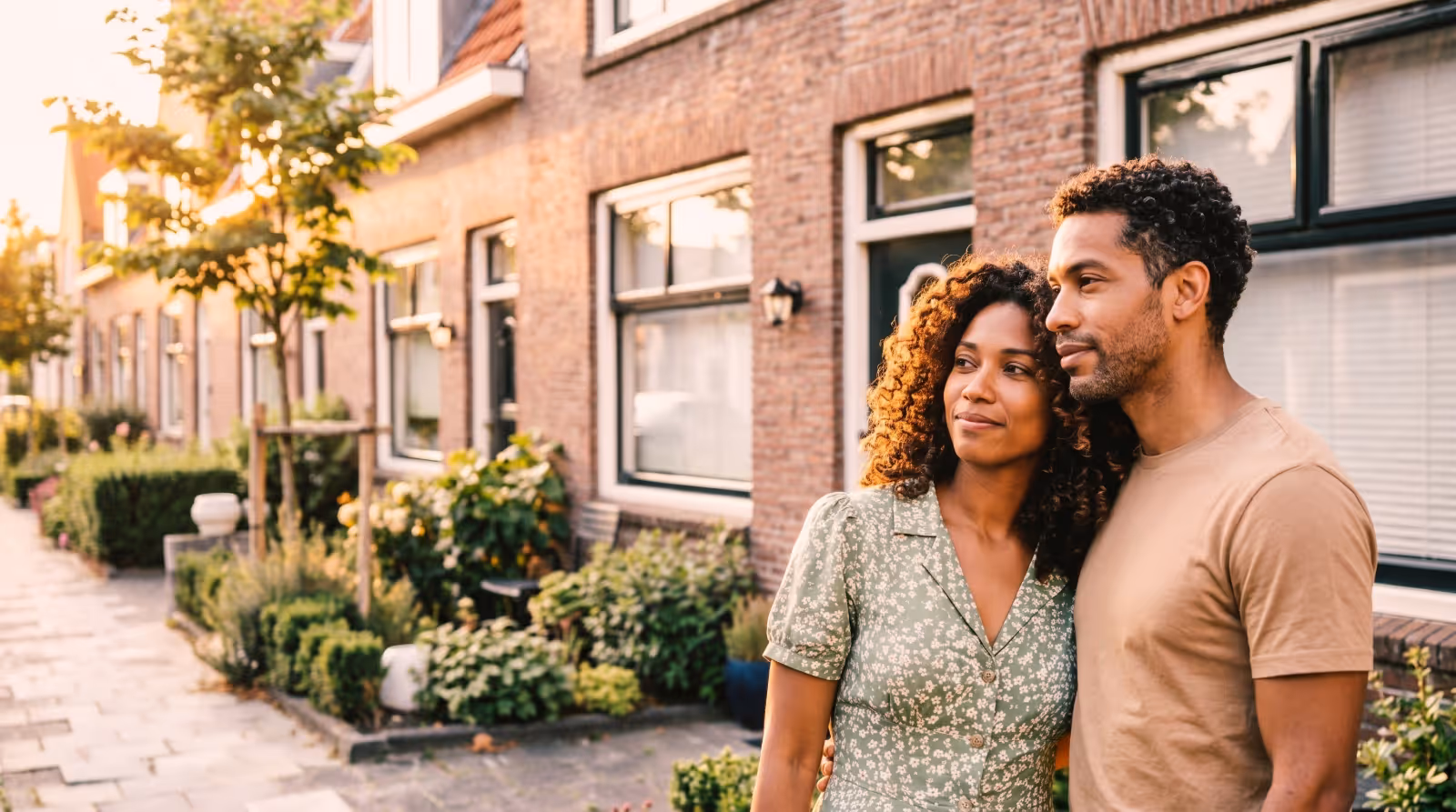 Een huiseigenaar staat ontspannen in de deuropening van een Nederlands huis, met sleutels in de hand