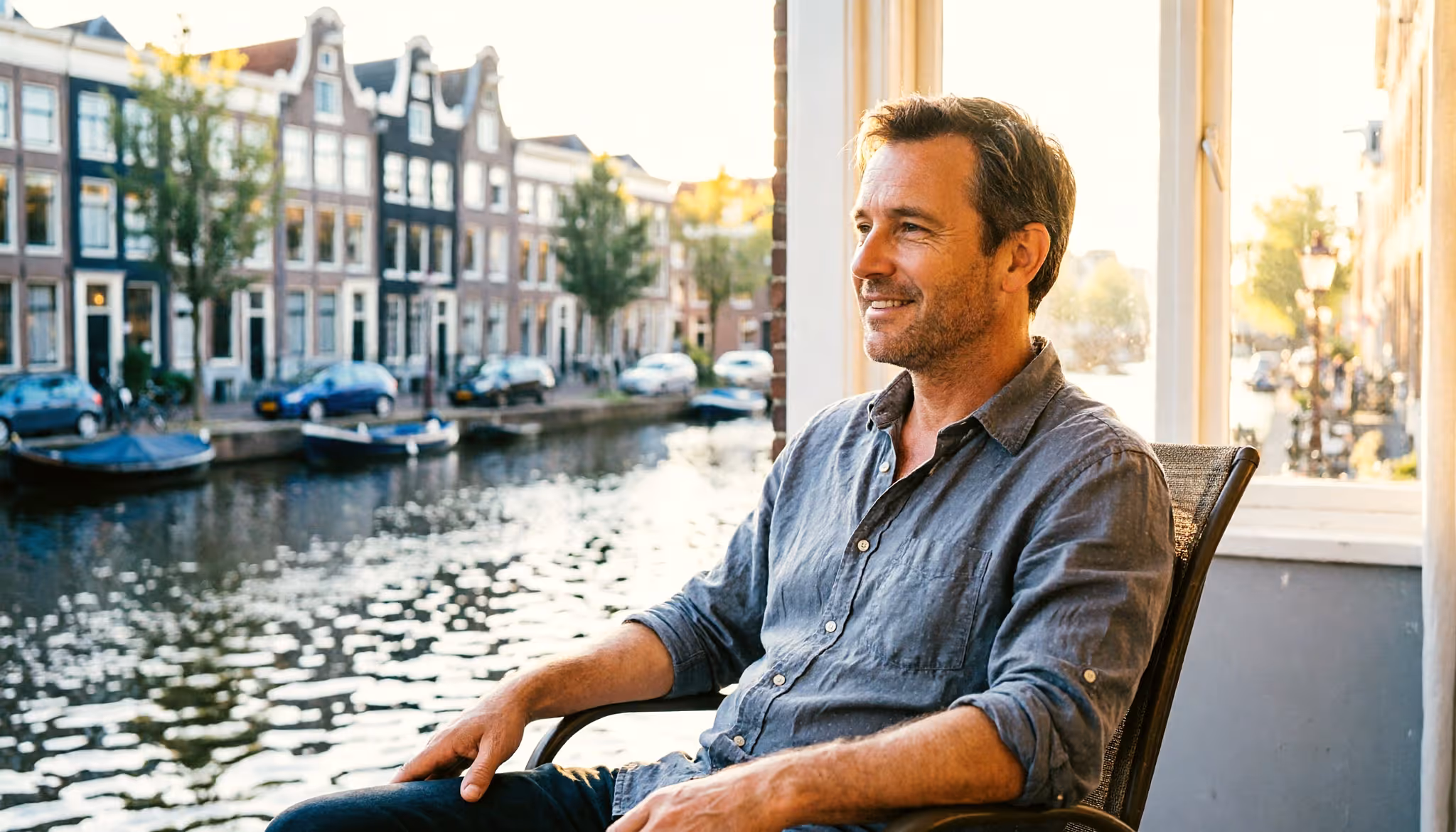 A man relaxes on the terrace of his canal-side house in Amsterdam